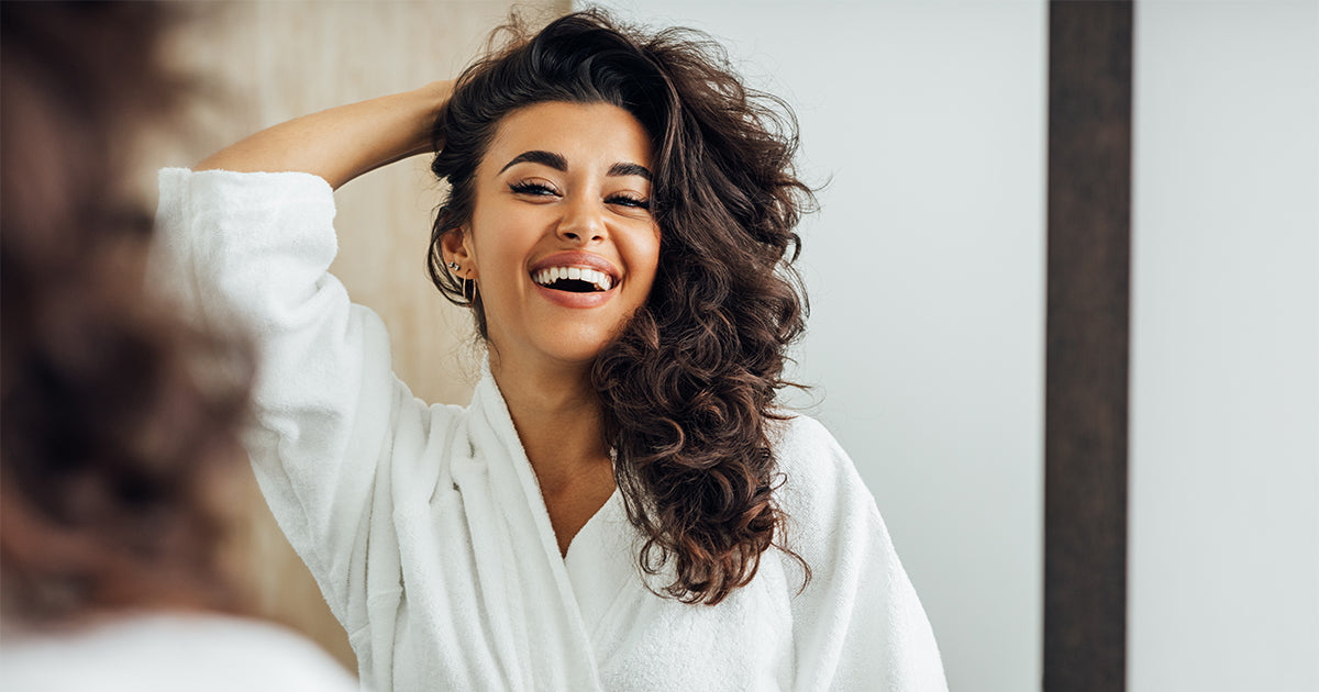 woman looking in mirror happy