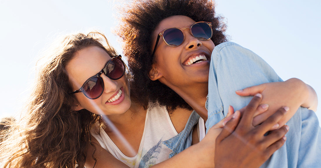 women smiling wearing sunglasses