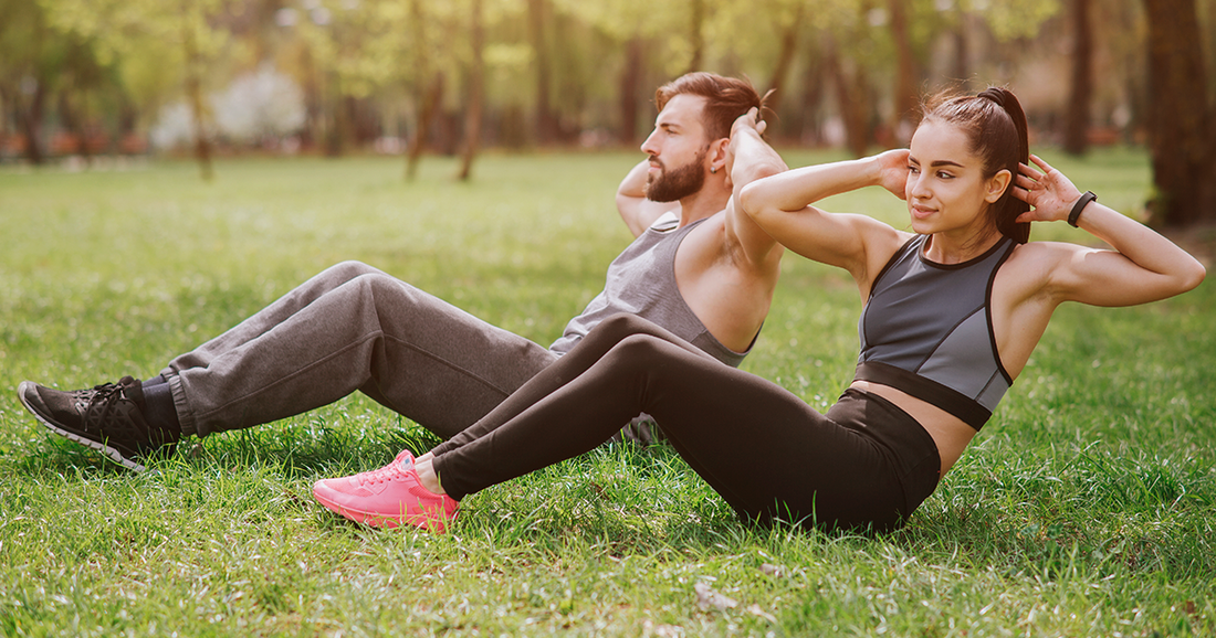 man and woman doing sit ups 
