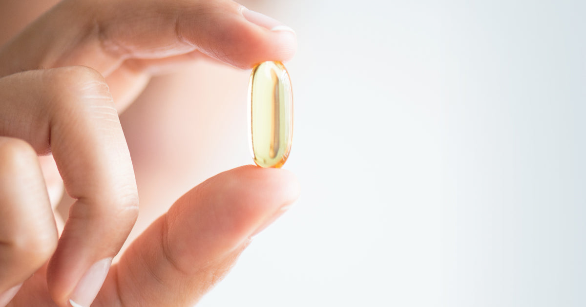 woman holding supplement capsule