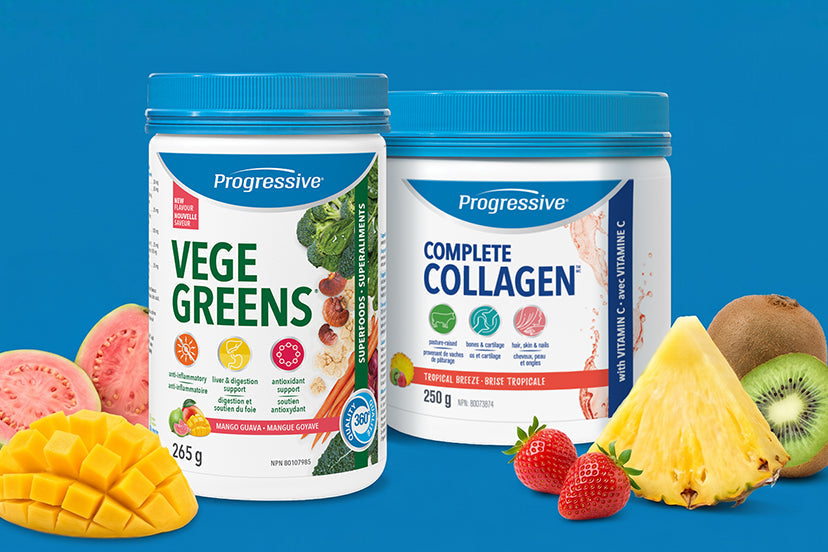 Two white Progressive supplement tubs with blue lids are shown on a bright blue background, surrounded by fruit slices and pieces including mango, watermelon, pineapple, kiwi, and strawberries. The tubs are labeled Vege Greens and Complete Collagen.